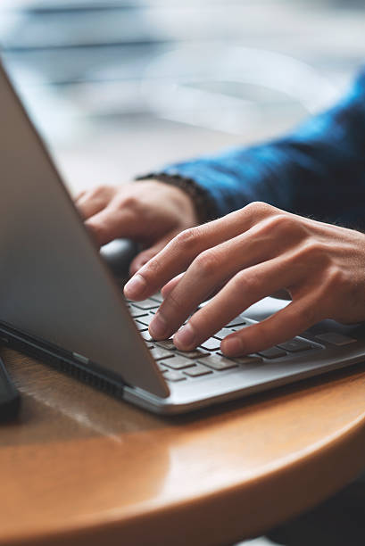 man typing on laptop