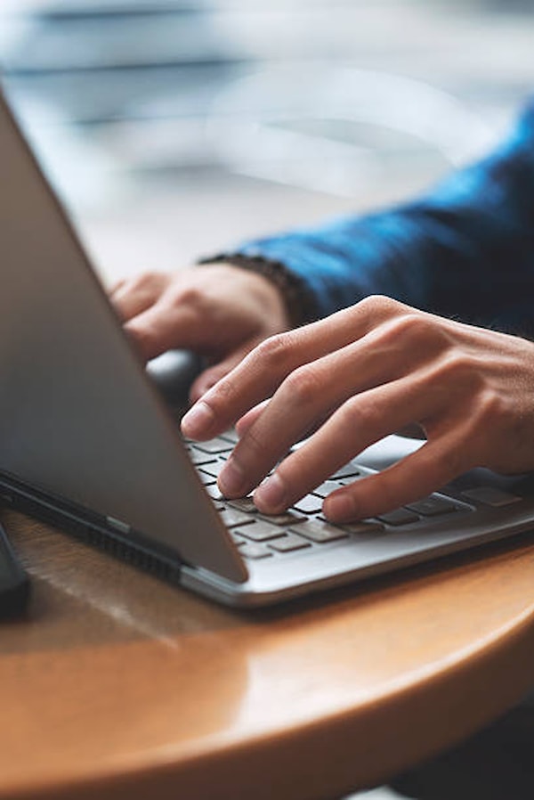 man typing on laptop