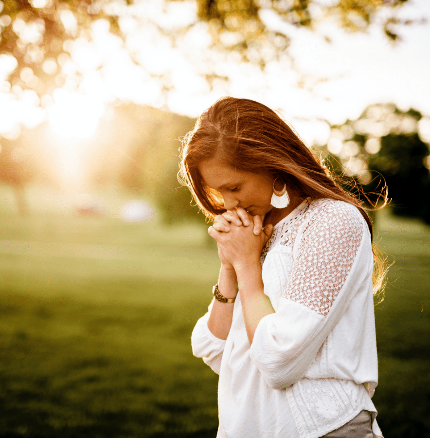 women lowering her head in prayer